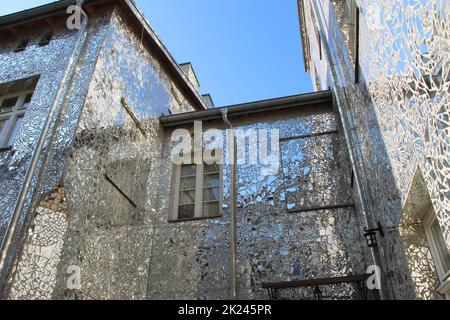 Bâtiment avec murs symétrisés. Façade de bâtiment en fragments de miroir. Murs de maison couverts de pièces de miroir. Bâtiment avec murs fabriqués à partir de mi Banque D'Images