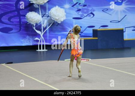 La jeune fille exécute un programme obligatoire de gymnastique rythmique Banque D'Images