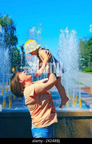 Une mère heureuse lance des enfants. Jeune femme adulte jouant avec une fille en bas âge. Bonne famille. Maman de jeter l'enfant, de s'amuser ensemble. Banque D'Images