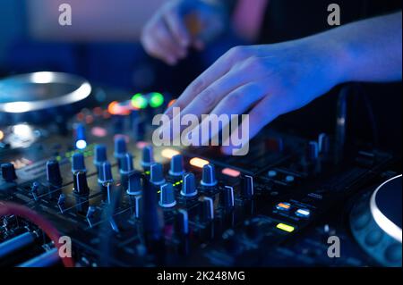 Gros plan sur le poste de contrôleur du DJ Mixer dans la discothèque Night Club Disco Party. Mains DJ touches et curseurs lecture de musique électronique . Photogra de haute qualité Banque D'Images