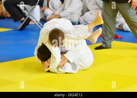 Deux garçons judoka dans kimono concourent sur le tatami Banque D'Images