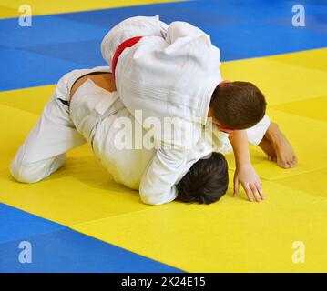 Deux garçons judoka dans kimono concourent sur le tatami Banque D'Images