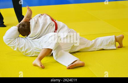 Deux garçons judoka dans kimono concourent sur le tatami Banque D'Images