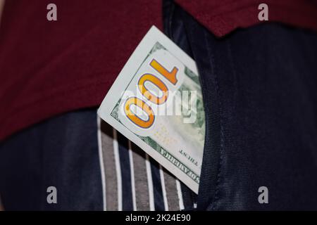 Un sac d'argent dans la poche du pantalon d'un homme.Des dollars dans votre poche. Banque D'Images