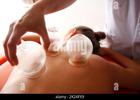 la femme se détend de la procédure d'acupuncture. Une acupuncture acupuncturiste doong très précisément. Médecine chinoise traditionnelle Banque D'Images