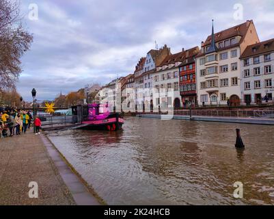 Strasbourg, Alsace, France - 30 décembre 2021 : tram fluvial avec touristes sur un canal d'eau sur le fond de maisons anciennes. Vue sur la rivière. Strasbourg ville, F Banque D'Images