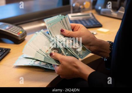 Le caissier compte les billets de banque en peso de la République dominicaine de 500 sur une table en bois. Change de devises sur le thème du voyage. Banque D'Images