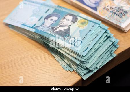 Lot complet de billets de banque de 500 peso en République dominicaine sur une table en bois. Change de devises sur le thème du voyage. Banque D'Images