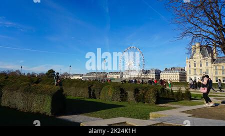 Paris, France - 01 janvier 2022: Personnes se trouvant près de la grande roue de la Roue de Paris sur la place de la Concorde depuis le jardin des Tuileries à Paris, France Banque D'Images