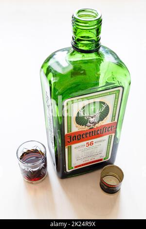 Moscou, Russie - 20 mars 2022 : grenaille et bouteille ouverte de liqueur de jagermeister sur table pâle. Jagermeister est allemand digestif fait avec 56 herbes et sp Banque D'Images