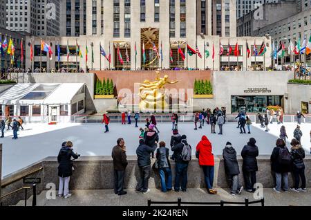 La Rink au Rockefeller Center pendant l'hiver, beaucoup de personnes patinent sur la glace tandis que les gens se tiennent devant les observer, la statue dorée de Prométhée et Banque D'Images