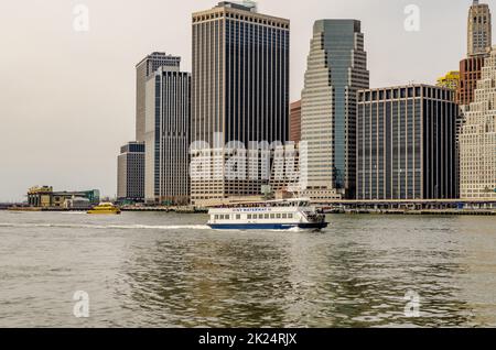 NY Waterway White Ferry devant le Skyline de Manhattan à East River dans la soirée, New York City, en hiver, horizontal Banque D'Images