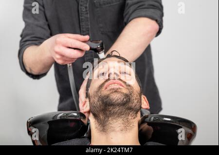 Salon de coiffure. Le coiffeur lave la tête du client dans le salon de coiffure. Photographie de haute qualité Banque D'Images