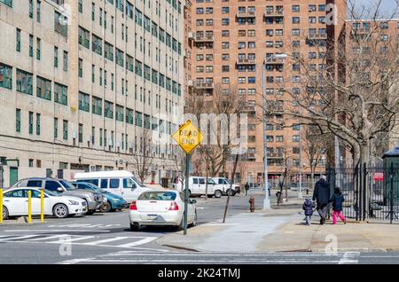 City Street avec des voitures garées et un panneau rouge Dead End jaune à Coney Island, Brooklyn, New York City pendant la journée d'hiver, les personnes marchant devant un résidentiel Banque D'Images