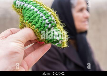 Masuleh, IRAN - 22 décembre 2017 gros plan d'une petite paire de chaussettes en laine avec un portrait de femme flou à l'arrière. Province de Gilan Banque D'Images