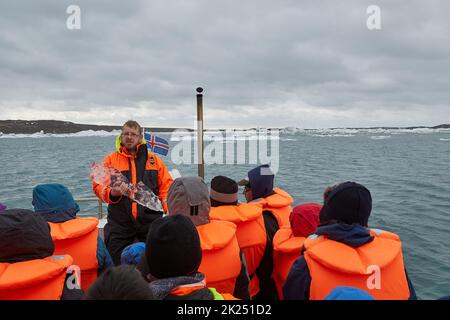 JOKULSARLON, ICELND - 10 MAI 2015: Guide parlant des icebergs lors d'une visite d'amphibiens sur le glacier du lac Jokulsarlon, Islande Banque D'Images