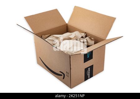 WETZLAR, ALLEMAGNE 2022-04-25: Boîte en carton Amazon Prime ouverte avec papier d'emballage sur fond blanc. Prime est un service offert par le détaillant en ligne A Banque D'Images