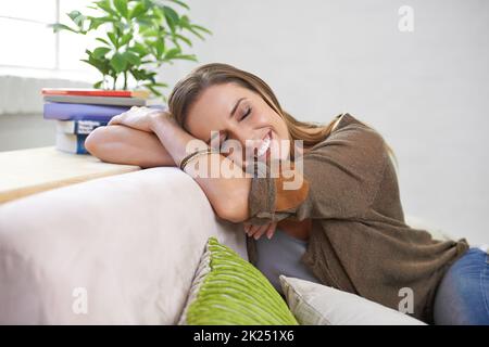 Elle s'est endormie sur le canapé. Une femme attrayante se détendant sur le canapé à la maison. Banque D'Images