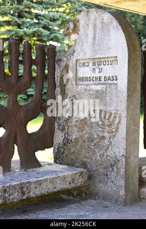 Lublin, Pologne - 24 mai 2022: Nouveau cimetière juif, vieux matzeva et clôture décorative en forme de menorah juive Banque D'Images