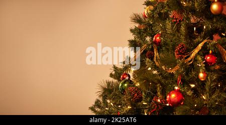 C'est la saison. Un arbre de Noël joliment décoré sur fond beige. Banque D'Images