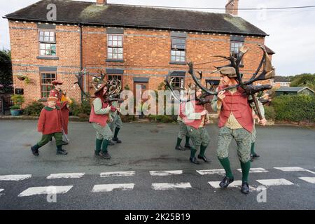 La danse annuelle de la Corne de Abbotts Bromley. Sur la photo, les cerfs-hommes dansent autour du village d'Abbotts Bromley. Les danseurs folkloriques retirent les cornes des murs de l'église Saint-Nicolas à 8am et se rendent à la danse toute la journée en visitant les villages voisins, en retournant les cornes pour une autre année aux murs du chuch à 8pm. Un service de bénédiction à 7am a lieu sous la direction de Revd Simon Davis.in 2022. La danse de la corne a lieu depuis le 12th siècle. Banque D'Images