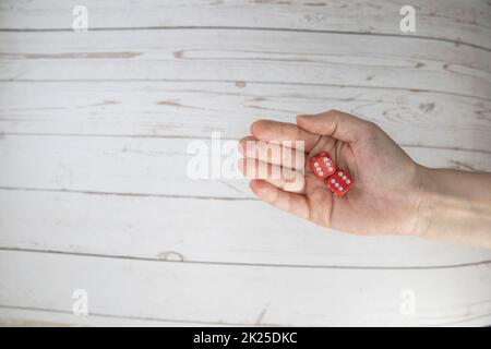 La main féminine tient les dés de jeu rouges sur fond blanc. Double six concept avec espace de copie pour jeux, jeu de société, jeu de rôle, risque, chance, bonne chance ou jeu. Vue de dessus de l'image en tons. Gros plan. Banque D'Images