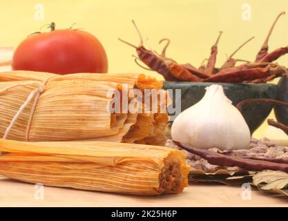 Tamales à l'ail, aux haricots et à la tomate sur fond jaune Banque D'Images