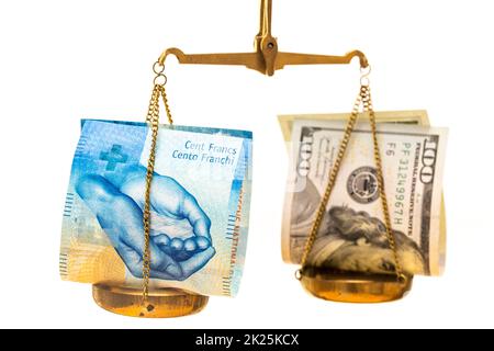 Swiss franc exchange rate against the US dollar, financial concept, both currencies lying on a scale on a white background, Money 100 dollars and fran Stock Photo