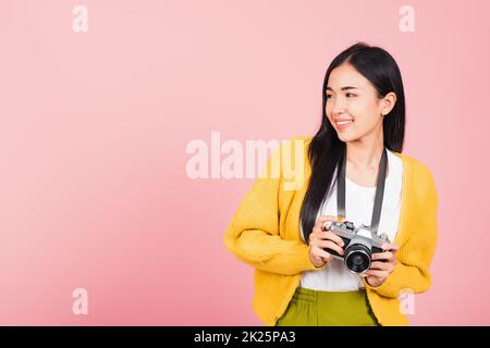 femme adolescente souriante tenant un appareil photo d'époque Banque D'Images