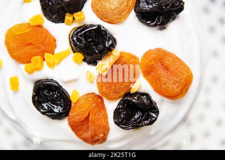 Un gâteau de Pâques décoré d'abricots et de pruneaux séchés se dresse sur un tablier bleu rayé. Concept de vacances religieuses de Pâques. Banque D'Images