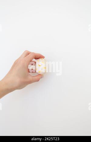 Fille tenant l'oeuf de Pâques peint avec des aquarelles dans ses mains, isolé sur fond blanc. Banque D'Images