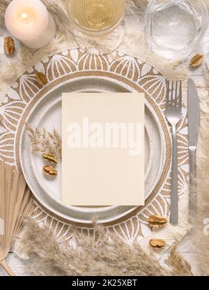 Table de mariage de boho avec carte vierge sur l'assiette près de l'herbe de pampas Banque D'Images