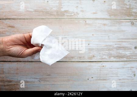 Une femme tient le papier de soie sur fond en bois, vue de dessus avec espace de copie, concept hygiénique propre Banque D'Images