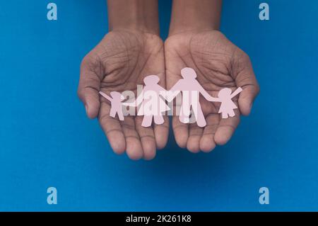 Vue du dessus de la découpe de la figurine familiale. Journée mondiale de la santé protection contre la violence domestique, les soins de santé et les antécédents médicaux. Concept de soins d'accueil, de soutien aux sans-abri et de distanciation sociale. Banque D'Images