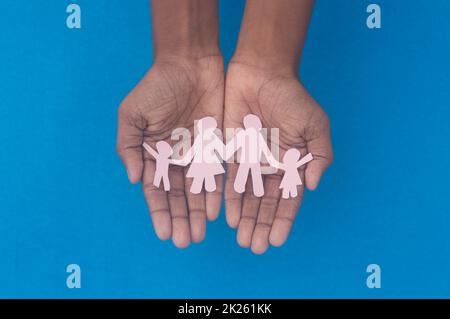 Vue du dessus de la découpe de la figurine familiale. Journée mondiale de la santé protection contre la violence domestique, les soins de santé et les antécédents médicaux. Concept de soins d'accueil, de soutien aux sans-abri et de distanciation sociale. Banque D'Images