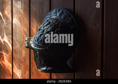 Casque en métal ancien accroché à des panneaux de bois Banque D'Images