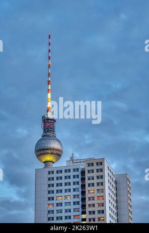 La célèbre tour de télévision de Berlin au crépuscule avec un immeuble d'appartements préfabriqué typique de GDR Banque D'Images