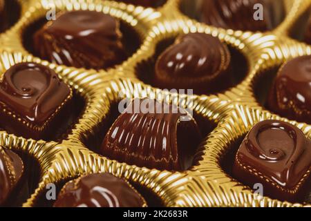 Variété de pralines au chocolat dans une boîte dorée Banque D'Images