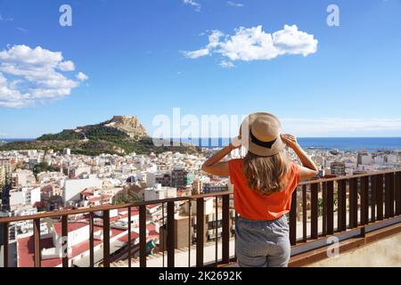 Femme touriste tenant chapeau et regardant le paysage urbain d'Alicante et le mont Benacantil avec le château de Santa Barbara et la mer sur fond, Espagne Banque D'Images