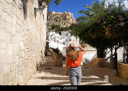 Explorer Alicante en Espagne. Jeune voyageur femme marchant dans le quartier Santa Cruz regardant le mont Benacantil avec le château de Santa Barbara à Alicante, Espagne. Banque D'Images