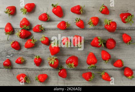 Vue sur table - fraise mûre fraîchement cueillie, renversé sur les planches de bois gris 24 Banque D'Images