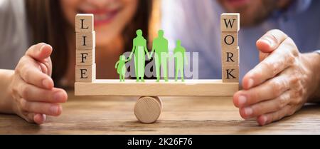 Couple protégeant un juste équilibre entre le travail et la vie sur Seesaw Banque D'Images