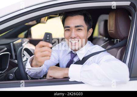Homme d'affaires souriant et montrant les clés de la voiture Banque D'Images