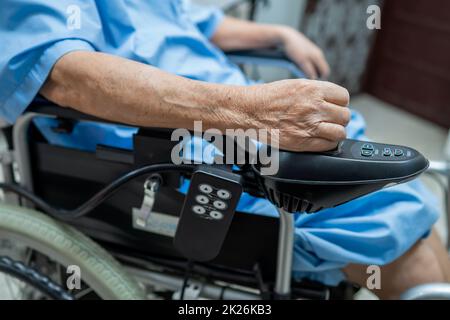 Femme asiatique senior ou âgée, femme en fauteuil roulant électrique avec télécommande dans un hôpital de soins infirmiers, concept médical sain et fort Banque D'Images