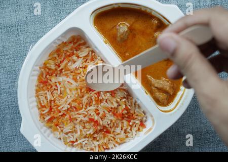 curry de poulet et de riz dans un sachet en plastique à emporter sur la table Banque D'Images