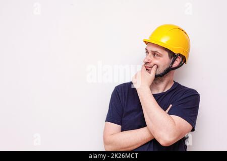 Travailleur d'interprétation derrière un fond blanc. Port d'un masque vert et d'un casque jaune Banque D'Images