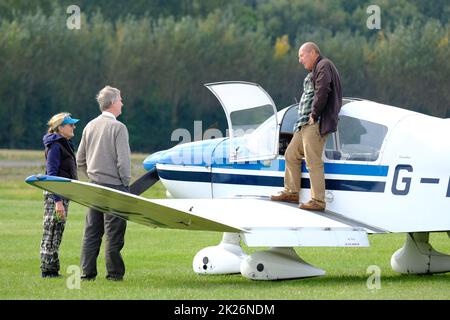 Le pilote de l'aviation générale et ses collègues parlent à côté d'un avion léger dans un aérodrome de graminées au Royaume-Uni septembre 2022 Banque D'Images