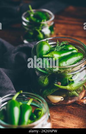 Poivrons en conserve Jalapeno, ail et aneth dans des jarres en verre Banque D'Images