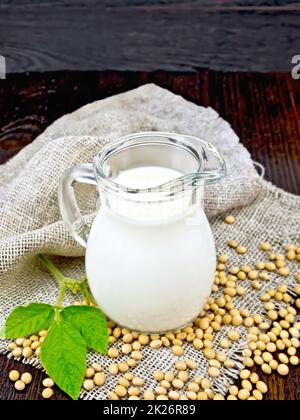 Lait de soja dans un pot avec soja et feuille à bord Banque D'Images