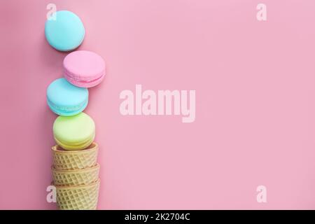 Macarons sur fond rose coloré, composition de biscuits français colorés macarons cadeau pour la Saint-Valentin Fête des mères vue du dessus de l'espace copie Banque D'Images